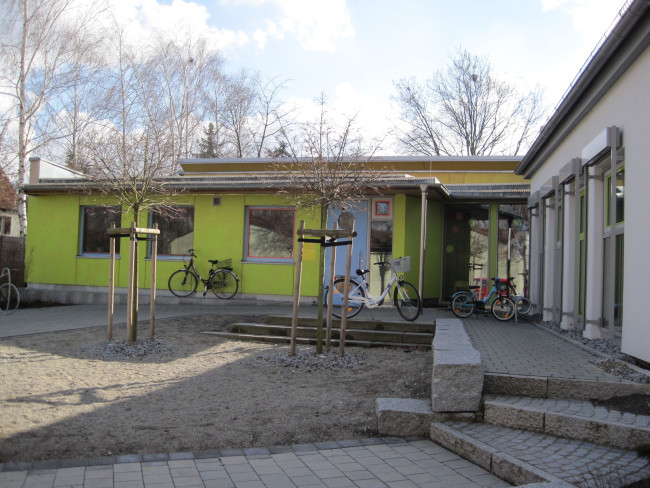Blick auf den Neubau des Kindergartens, rechts ist ein Teil des Altbaus zu sehen. Im Vordergrund der Vorplatz